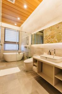 員山郷にある優勝美地民宿二館の浴槽、トイレ、洗面台を備えたバスルーム