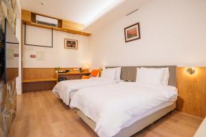 員山郷にある優勝美地民宿二館のベッド2台と机が置かれた寝室 +4枚の写真