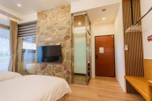 員山郷にある優勝美地民宿二館の石壁のベッドルーム(テレビ付)