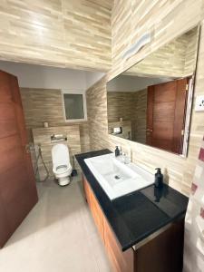 un bagno con lavandino e WC di Kandy Villa Grey a Talatuoya