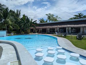 a swimming pool with stools next to a house at Banana Beach Club in Moalboal +7 photos
