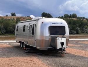 une remorque argentée garée sur le côté d’une route dans l'établissement Wonderful Airstream in Grand Junction, Perfect for Glamping Getaways in Colorado, à Grand Junction