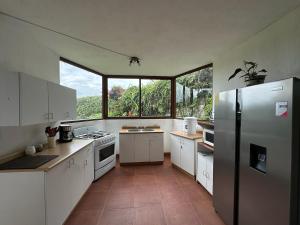 cocina con electrodomésticos blancos y ventana grande en Casa Belen Panajachel, en Panajachel