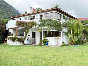 una casa blanca con un césped verde delante de ella en Casa Belen Panajachel, en Panajachel