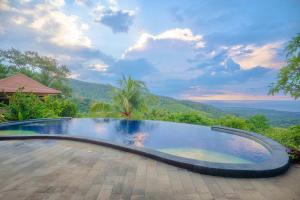 a swimming pool with a view of the mountains at Maria Secret Villa in Lovina