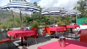 Un grupo de mesas con sombrillas en un patio. en Amri's Villa, en Mount Abu