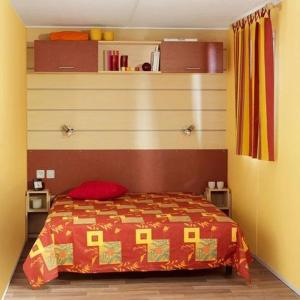 a bedroom with a bed with a red blanket at Camping 3 étoiles - Piscine - eeed0b in Bédouès