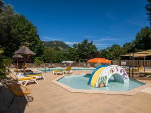 a swimming pool with a slide in the middle at Camping 3 étoiles - Piscine - eeed0b in Bédouès