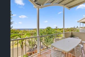a patio with a table and chairs on a balcony at Unit 15 - 45 Lorikeet Drive, Peregian Beach in Peregian Beach