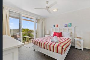 a white bedroom with a bed and a balcony at Unit 15 - 45 Lorikeet Drive, Peregian Beach in Peregian Beach +8 photos
