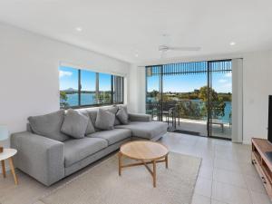 een woonkamer met een bank en een tafel bij Foreshore Bradman in Diddillibah