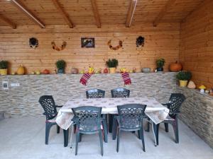 a table and chairs in a room with a brick wall at Pensiunea Silver in Caciulata