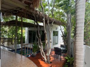 un porche de una casa con mesa y sillas en Ban Khao Tao Beach, en Sathani Khao Tao