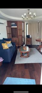 Una sala de estar con un sofá azul y una mesa. en Ban Khao Tao Beach, en Sathani Khao Tao