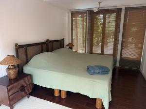 1 dormitorio con 1 cama con manta verde y ventanas en Ban Khao Tao Beach, en Sathani Khao Tao