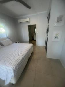 a bedroom with a white bed and a tile floor at Reid's Retreat - Studio Apartment in Port Douglas +13 photos