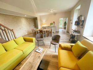 a living room with a yellow couch and a table at Gîte à Manthelan : Confort et Charme, Jardin, Wi-Fi - FR-1-381-639 in Monfoué