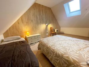 a attic bedroom with a bed and a window at Gîte à Manthelan : Confort et Charme, Jardin, Wi-Fi - FR-1-381-639 in Monfoué +16 photos