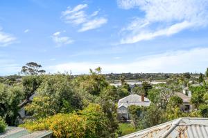 uma vista do telhado de uma casa com árvores em Bespoke Stays - Rustic Stanley Bay Apartment em Auckland mais 7 fotografias