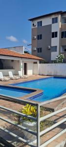 a swimming pool with chairs and a building at Conforto e Lazer no Coração da Ilha de São Luís in São-José-do-Ribamar