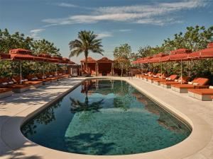 a pool at the resort with chairs and umbrellas at The EVE Hotel Sydney in Sydney
