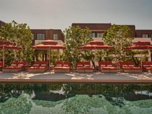 een zwembad met stoelen en parasols en een gebouw bij The EVE Hotel Sydney in Sydney