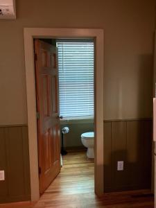 an open door to a bathroom with a toilet at Family-Friendly Cabin with Private Hot Tub near Charlotte, North Carolina in Elkin