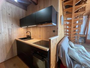 a kitchen with a sink and a stove in a room at Chalet montagnard avec balcon, proche piste et centre - FR-1-814-77 in Besse-et-Saint-Anastaise