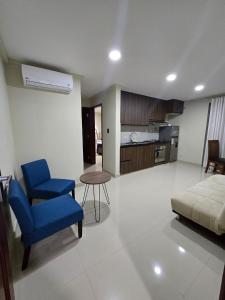 een woonkamer met een blauwe stoel en een bank bij Edificio El Molino in Tarija