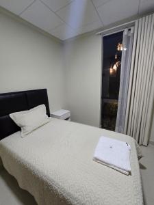 een wit bed in een kamer met een raam bij Edificio El Molino in Tarija