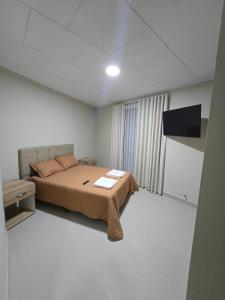 een slaapkamer met een bed en een flatscreen-tv bij Edificio El Molino in Tarija