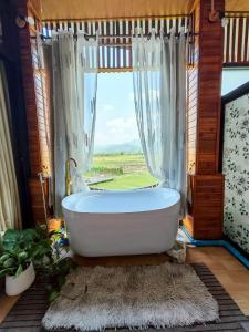 a bath tub in a bathroom with a window at บ้านฮิมนาปัวรีสอร์ท in Pua