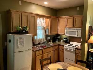a kitchen with wooden cabinets and a white refrigerator at Family-Friendly Cabin with Private Hot Tub near Charlotte, North Carolina in Elkin