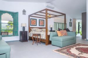 a bedroom with a large canopy bed and a chair at Sinharaja River Lodge in Nikawatawana +21 photos