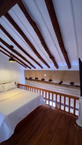 a bedroom with a white bed and wooden floors at Hotel Don Eduardo Quintero M in Pinchote
