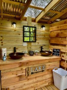 une salle de bain avec deux lavabos dans un mur en rondins dans l'établissement Beautiful Bell Tents for Lakeside Glamping near Knoxville, Tennessee, à Bean Station