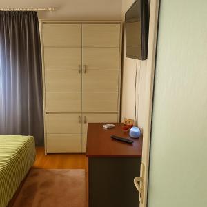 a bedroom with a bed and a desk with a television at Salcia Riverside Apartment in Galaţi +4 photos