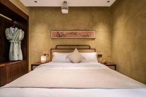 Ένα ή περισσότερα κρεβάτια σε δωμάτιο στο Chengdu Xiaoya Yard Hot Spring Hotel,is just a 20 minute drive from both the Sanxingdui Museum and the Chengdu Panda Base,Enjoy Soaking in natural hot springs,Traditional Chinese afternoon tea,Exquisite fruit platter +165 φωτογραφίες