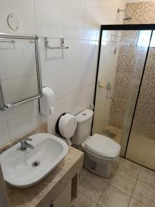 a bathroom with a toilet and a sink and a shower at Villa Anto in Encarnación +14 photos