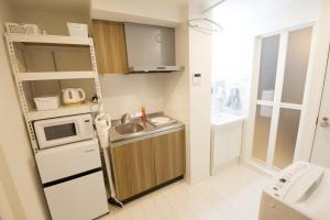 a small kitchen with a sink and a microwave at オーブリオン恵比寿203 in Tokyo