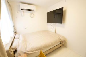 a small room with a bed and a clock on the wall at オーブリオン恵比寿203 in Tokyo