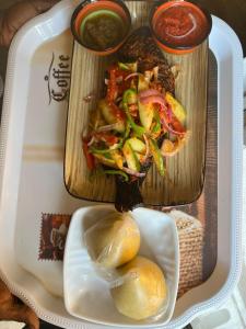 ein Tablett mit Essen und ein Teller mit Essen in der Unterkunft Dubai Dollar Beach Resorts in Tema