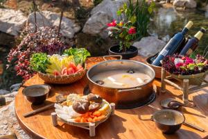 een tafel met kommen eten en groenten bij Chengdu Xiaoya Yard Hot Spring Hotel,Enjoy Soaking in natural hot springs,Traditional Chinese afternoon tea,Exquisite fruit platter in Longqiao