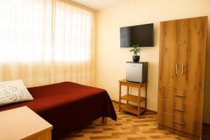 Un dormitorio con una cama y una cómoda con televisión. en Departamento amoblado en primer piso 200 MTS a tu disposición con todos los servicios, en Tacna 6 fotos más