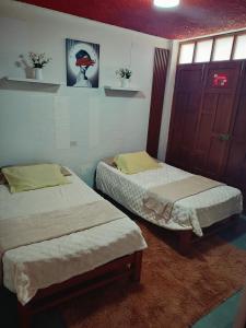 two twin beds in a room with at Departamento amoblado en primer piso 200 MTS a tu disposición con todos los servicios in Tacna