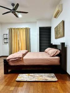 a bedroom with a large bed with a ceiling fan at JM House Kuala Lumpur in Puchong +6 photos