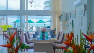 a dining room with a table and chairs and the ocean at Hikka House - Thema Collection in Hikkaduwa