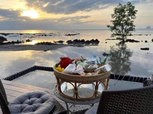a basket of food sitting on a table next to a body of water at บ้านหัวเรือโฮมสเตย์เกาะลิบง Baan huaruea homestay in Ko Libong