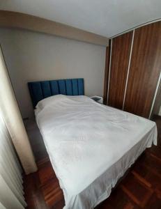 Bett mit blauem Kopfteil in einem Zimmer in der Unterkunft los hirukus cusco in Cusco