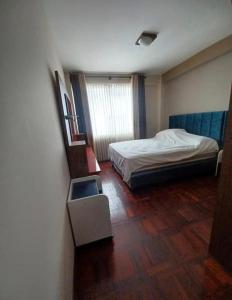 ein kleines Schlafzimmer mit einem Bett und einem Fenster in der Unterkunft los hirukus cusco in Cusco